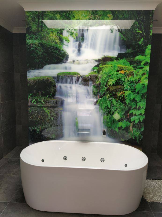 bathroom glass splashback ideas - a splashback with an image of a waterfall behind a bath