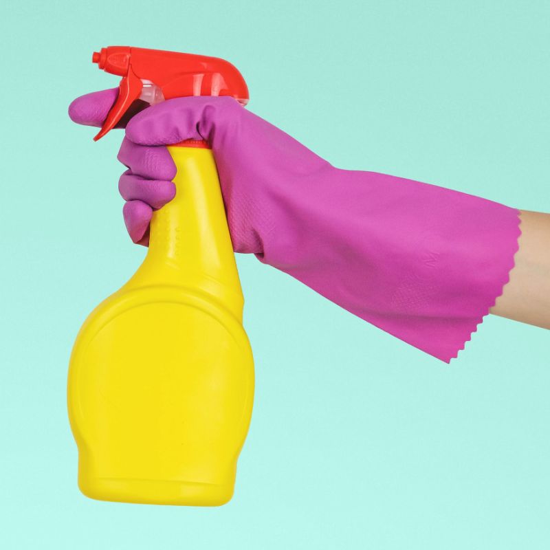 How to clean glass splashbacks - a hand holding a spray bottle